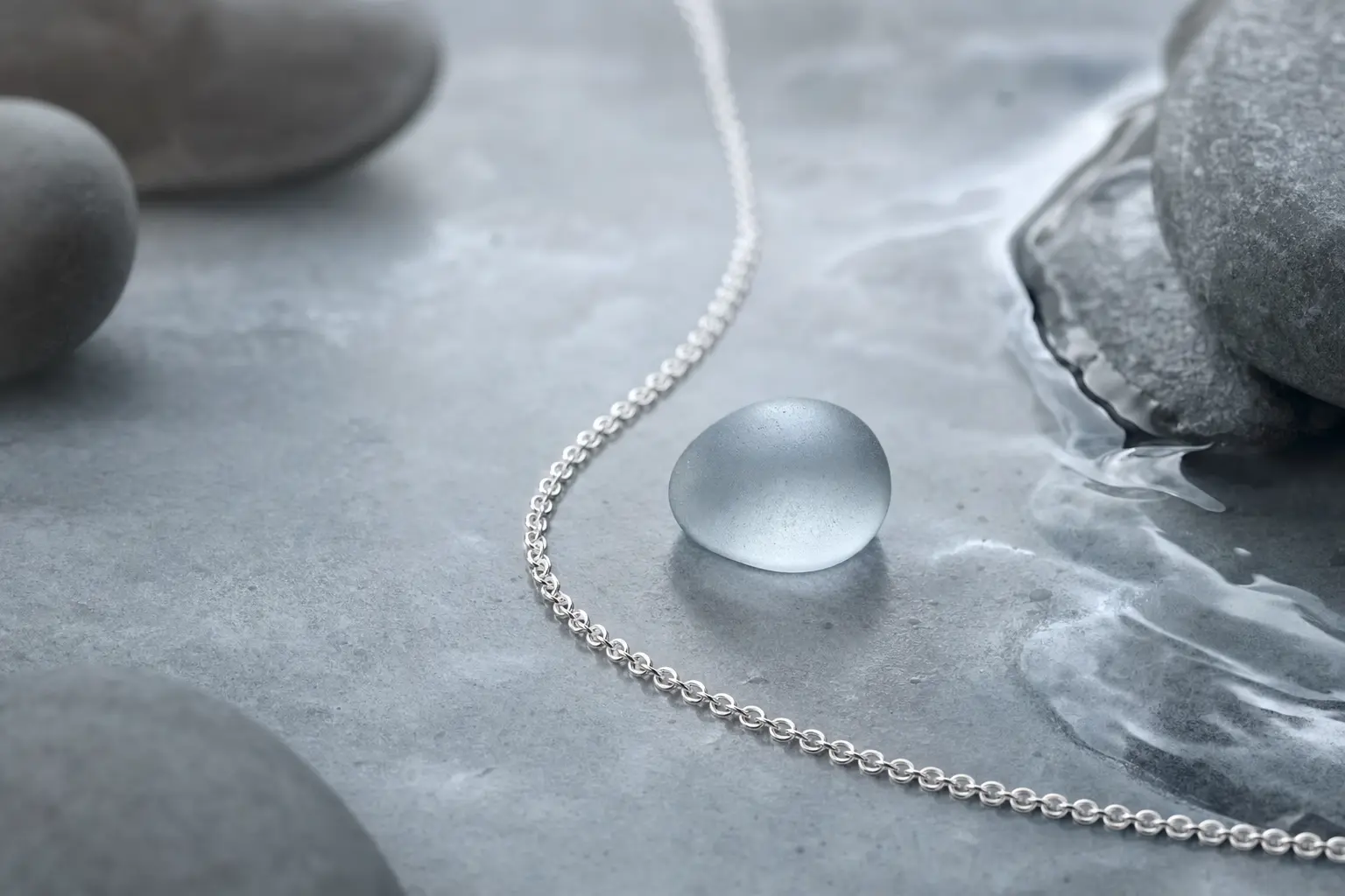 Silver chain with smoky glass pieces in a cool mineral still life