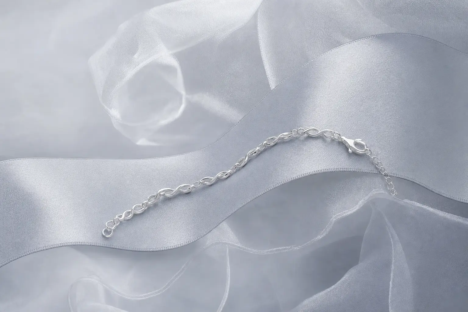 Slim silver bracelet crossing translucent silver-gray fabric