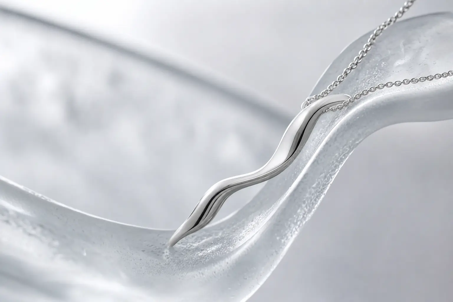Polished silver ribbon-form component following a frosted glass curve