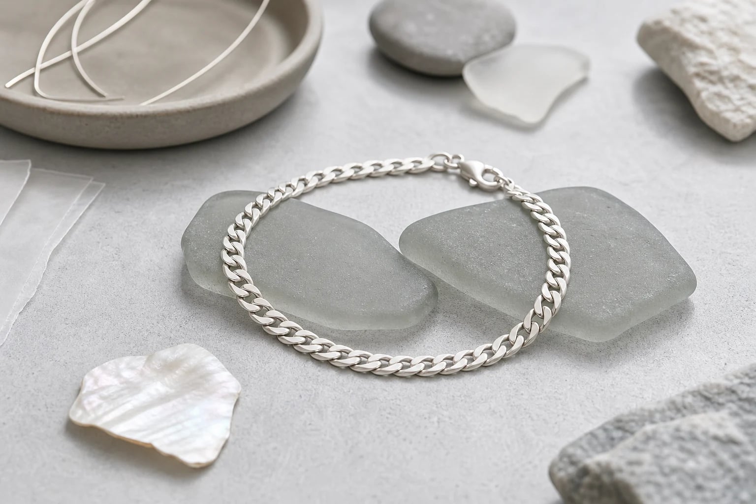 Silver curb chain bracelet circling over frosted sea-glass shards